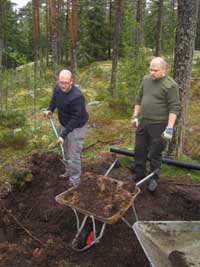 T�sin isot miehet tositoimissa, peitt�m�ss� viem�reit� turpeella.